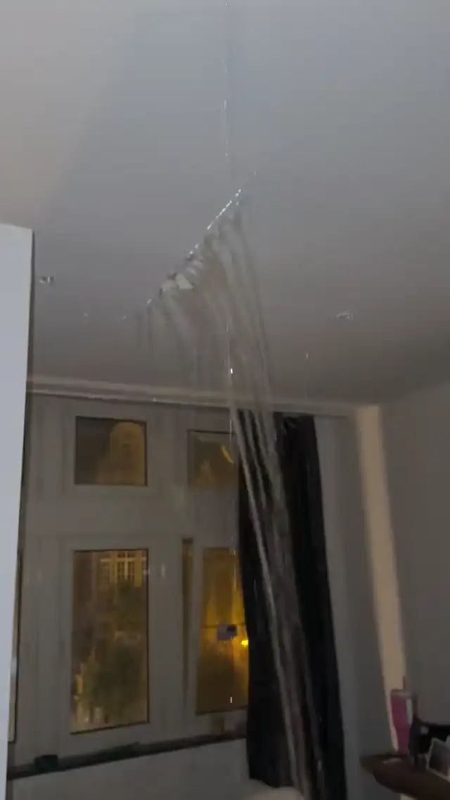 Water pouring through a storm-damaged ceiling